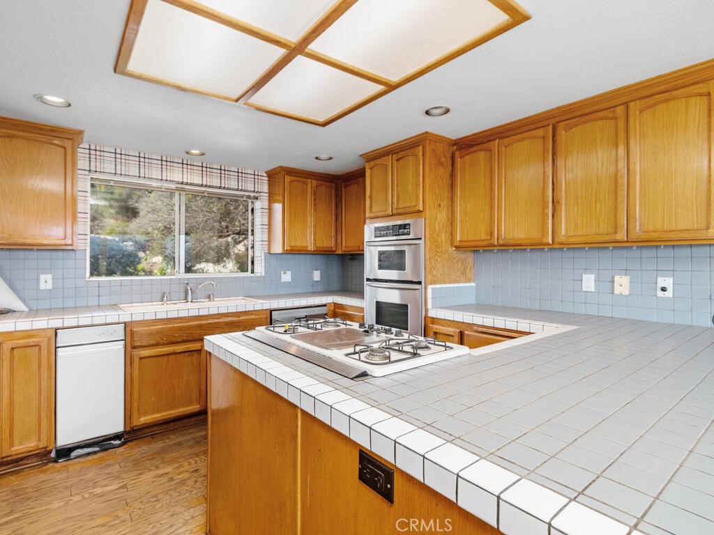 6455 Rainbow Heights Road Fallbrook, CA 92028 - Photo 17 of 63 a kitchen with stainless steel appliances granite countertop a sink window and cabinets