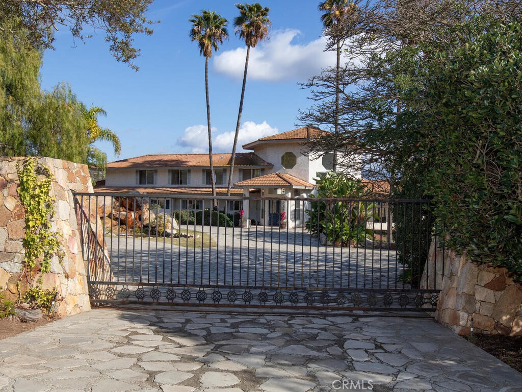 6455 Rainbow Heights Road Fallbrook, CA 92028 - Photo 2 of 63 a view of a brick house with a small yard and a large tree