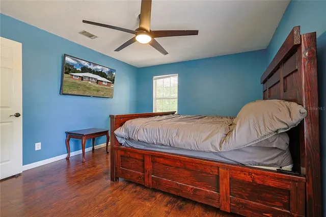 a bedroom with a bed and a painting on the wall