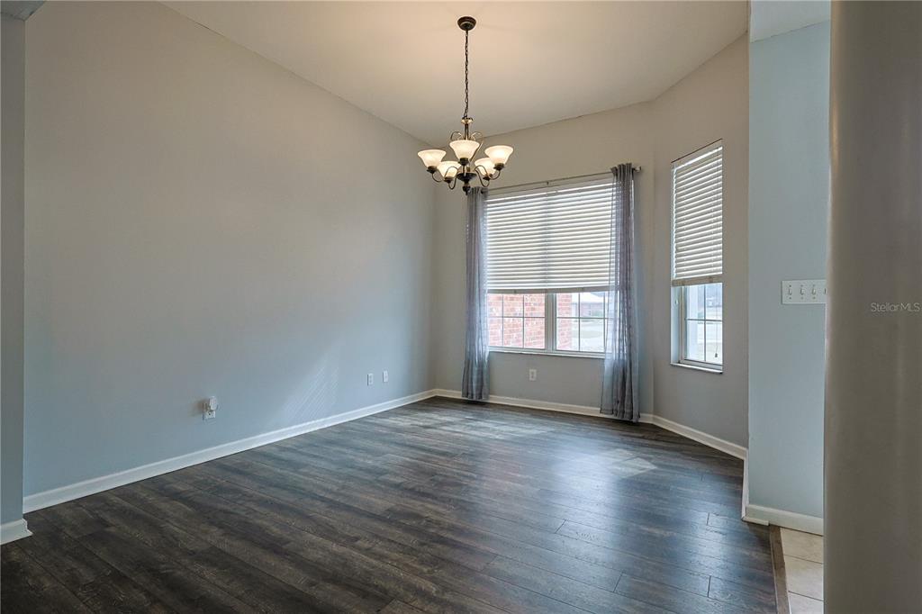 166 Southwest Hancock Court Lake City, FL 32024 - Photo 19 of 46 a view of a room with wooden floor chandelier and windows