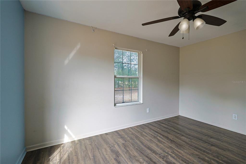 166 Southwest Hancock Court Lake City, FL 32024 - Photo 29 of 46 a view of an empty room with wooden floor and a window