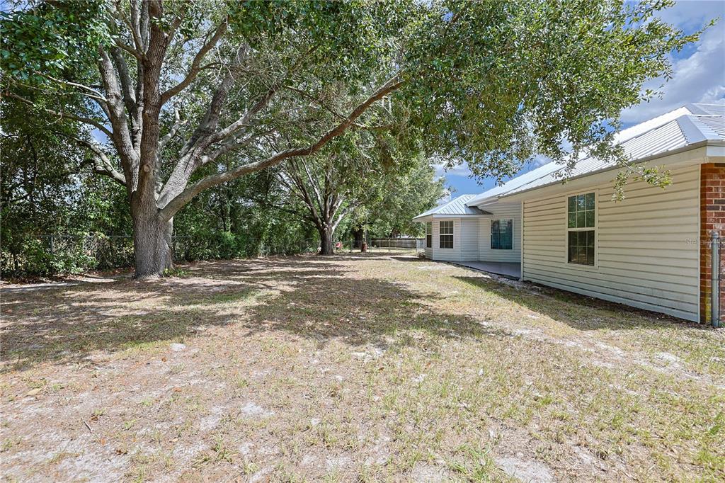 166 Southwest Hancock Court Lake City, FL 32024 - Photo 34 of 37 a backyard of a house with large trees and parked