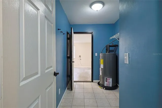 a view of a refrigerator in kitchen and an empty room