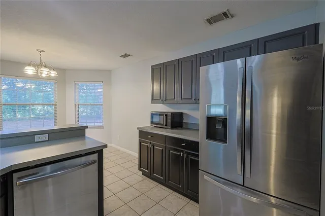 a kitchen with granite countertop a refrigerator stove and sink