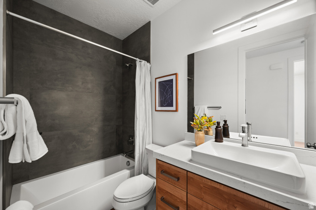 507 West Windmill Gate Cove Draper, UT 84020 - Photo 4 of 46 Full bath with vanity, shower / bath combo with shower curtain, and a textured ceiling
