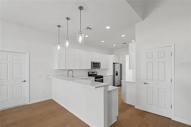 a kitchen with white cabinets and appliances