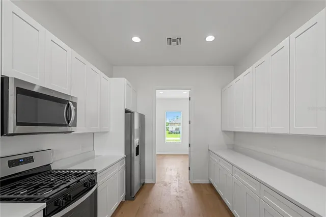 a kitchen with stainless steel appliances white cabinets and a stove