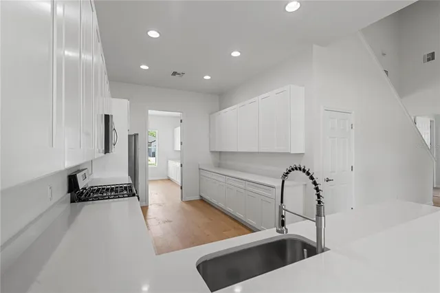 a view of a big room with wooden floor and windows