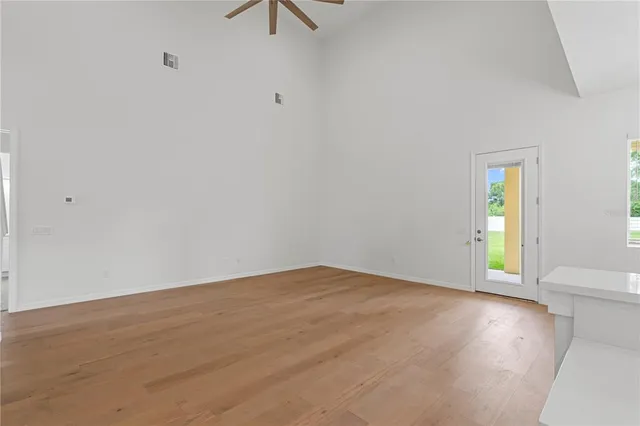 an empty room with a window and a fan