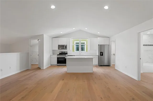 an empty room with windows and ceiling fan