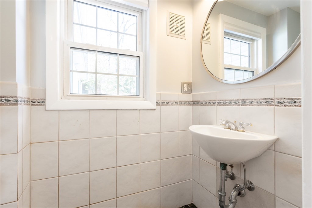 587 Greendale Avenue Needham, MA 02492 - Photo 15 of 36 a bathroom with a sink a mirror and a window