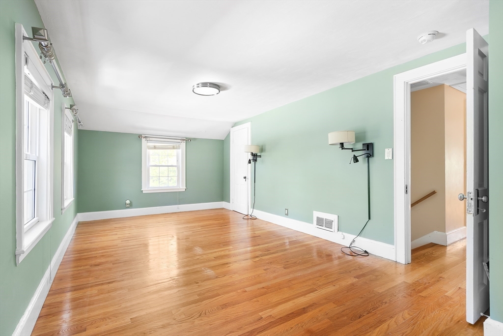 587 Greendale Avenue Needham, MA 02492 - Photo 17 of 36 a view of an empty room with window and wooden floor