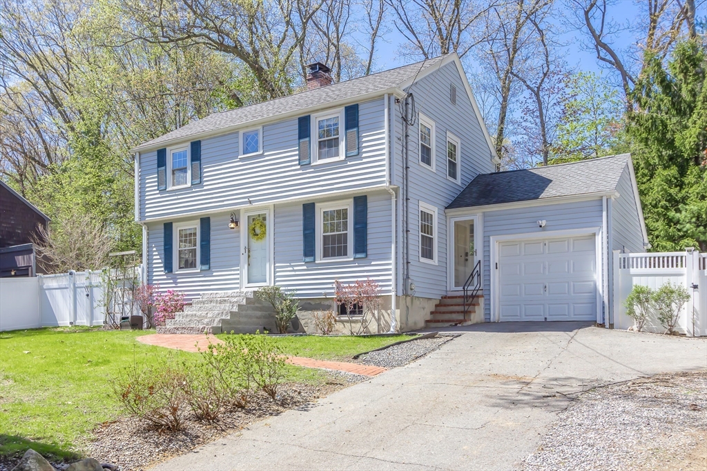 587 Greendale Avenue Needham, MA 02492 - Photo 2 of 36 a front view of a house with a yard and garage