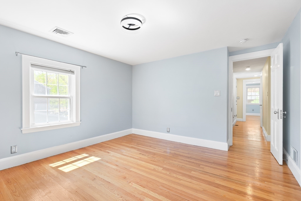 587 Greendale Avenue Needham, MA 02492 - Photo 22 of 36 an empty room with wooden floor and windows