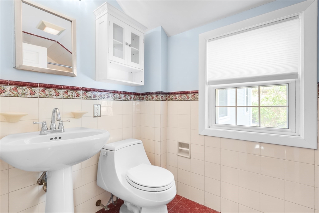 587 Greendale Avenue Needham, MA 02492 - Photo 26 of 36 a bathroom with a sink a toilet and a mirror