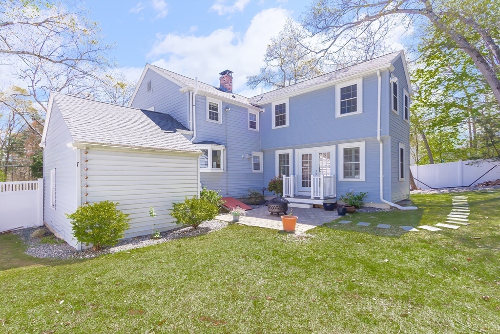587 Greendale Avenue Needham, MA 02492 - Photo 29 of 36 a view of a brick house with a yard patio and a fire pit