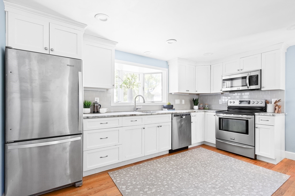 587 Greendale Avenue Needham, MA 02492 - Photo 3 of 36 a kitchen with white cabinets and white appliances