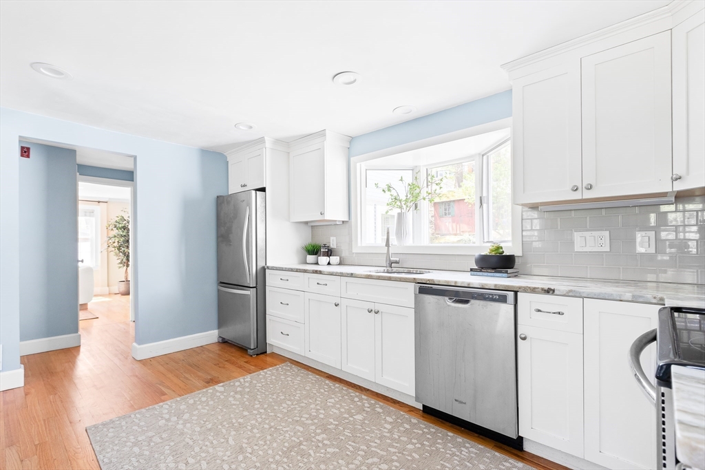 587 Greendale Avenue Needham, MA 02492 - Photo 4 of 36 a kitchen with refrigerator sink and cabinets