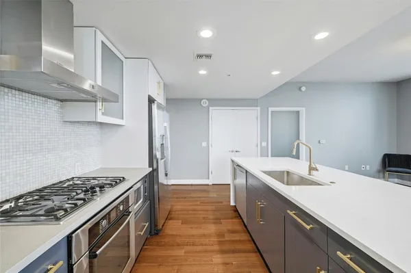 a kitchen with sink stove and cabinets