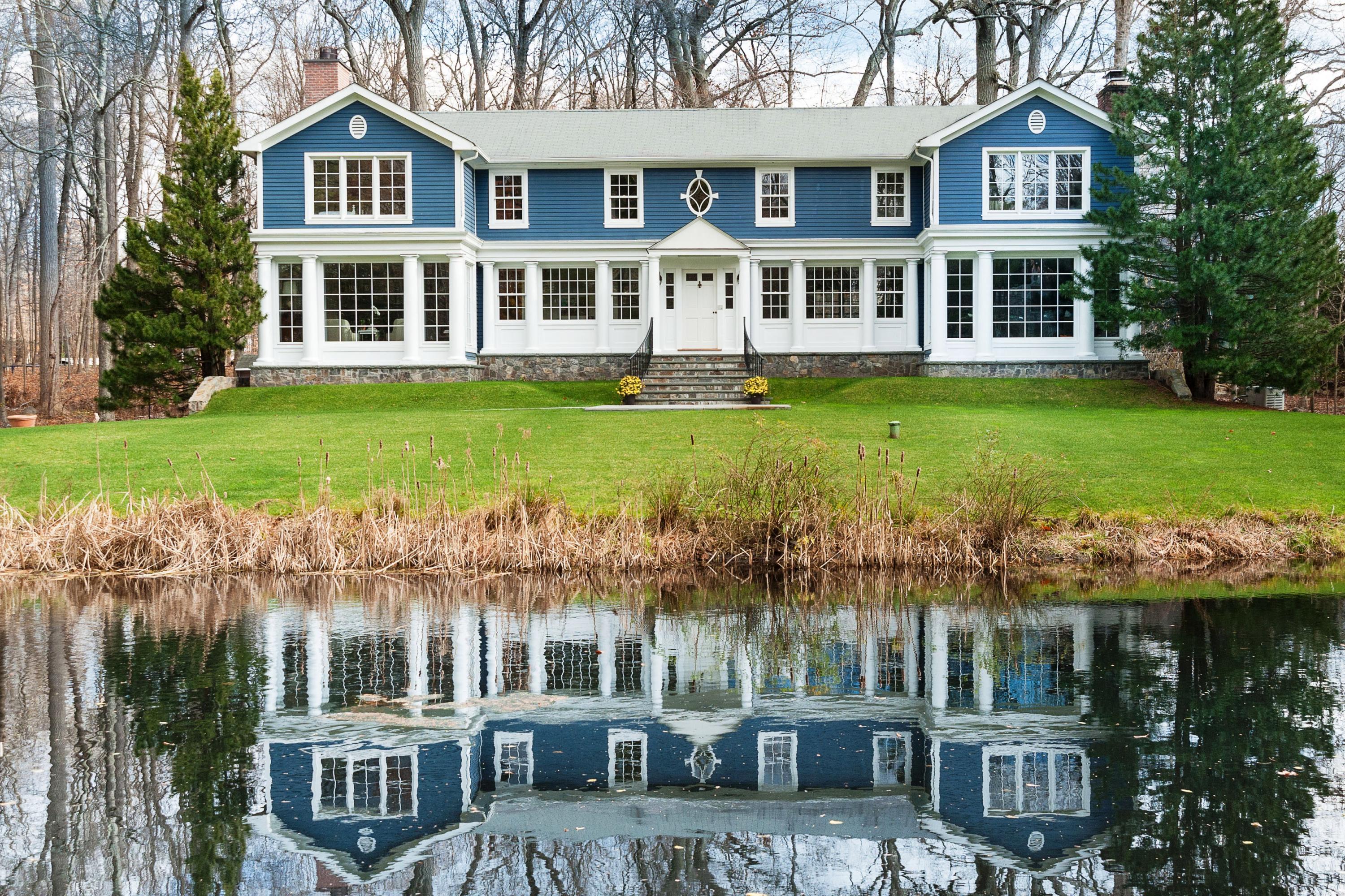 89 Dabney Road New Canaan, CT 06840 - Photo 2 of 40 a front view of a building with a garden and plants
