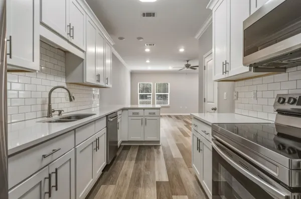 a kitchen with a sink stove and cabinets