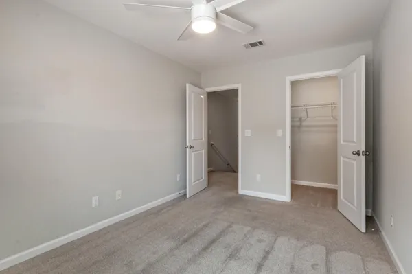 an empty room with fan and entrance