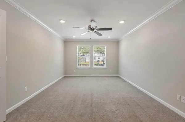 an empty room with windows and ceiling fan