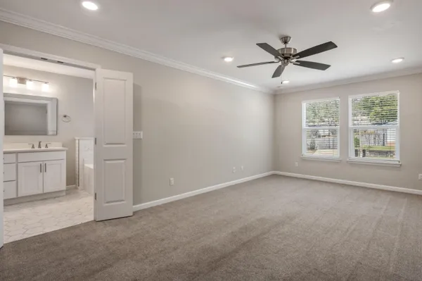 a view of an empty room with a window and a kitchen