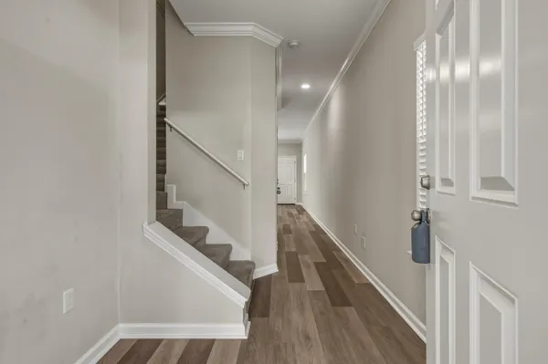 a view of entryway and hall with wooden floor
