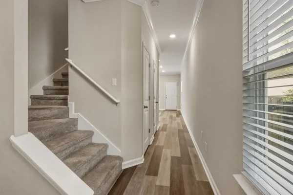 a view of a hallway with wooden floor and staircase