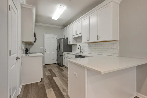 a kitchen with white cabinets and white appliances