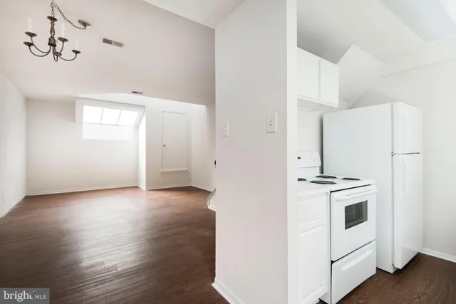 a kitchen with stainless steel appliances a refrigerator a stove and white cabinets