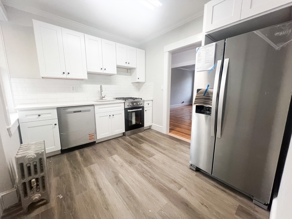 56 Selkirk Road, Unit 11 Boston, MA 02135 - Photo 1 of 6 a kitchen with a refrigerator a sink and dishwasher