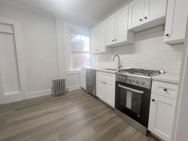 a kitchen with granite countertop white cabinets and white appliances