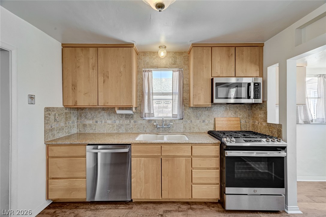 629 L Avenue Boulder City, NV 89005 - Photo 16 of 46 Kitchen with light, updated countertops, stainless steel appliances, decorative backsplash, and light wood finish cabinetry