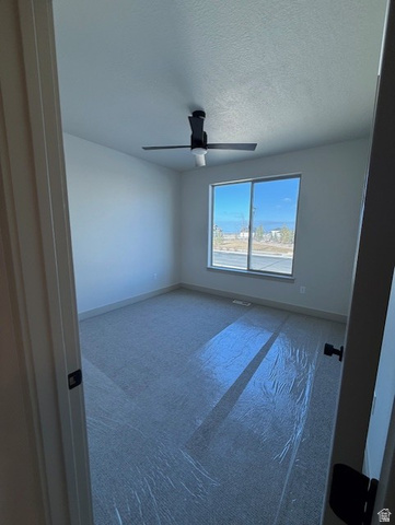 533 West S Temple Street, Unit 309 Tooele, UT 84074 - Photo 18 of 24 Carpeted spare room featuring a textured ceiling and ceiling fan