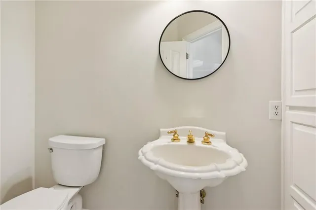 a bathroom with a sink a toilet and a mirror