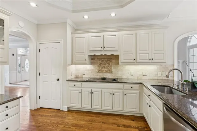a kitchen with granite countertop white cabinets and stainless steel appliances