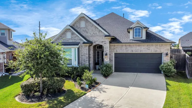 a front view of a house with a yard and potted plants