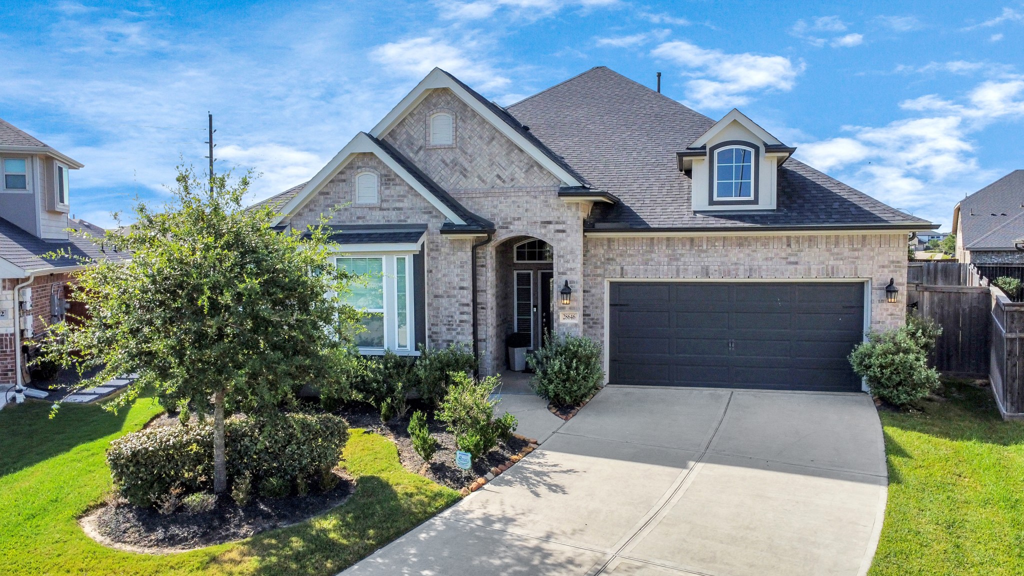 a front view of a house with a yard and potted plants