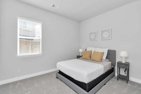 a bedroom with a bed lamp and a window