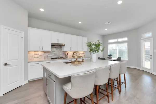 a view of kitchen with sink dining table and chairs