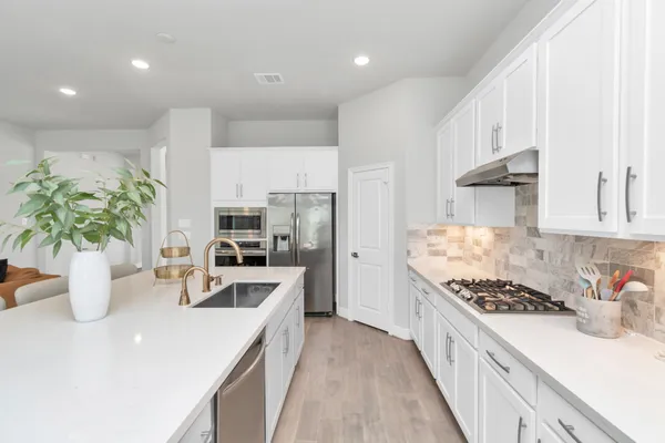 a kitchen with sink a stove and cabinets