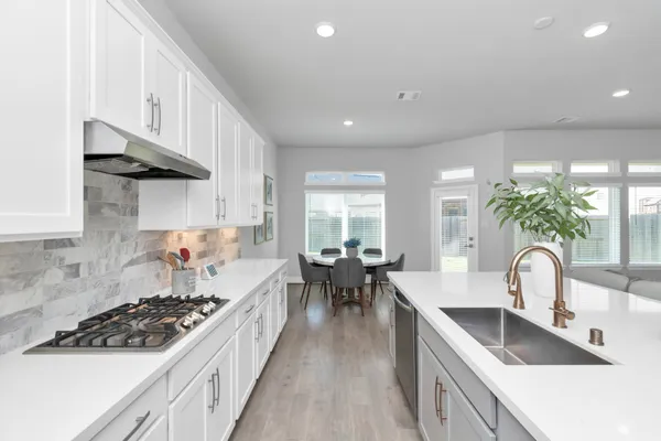 a kitchen with stove a sink and cabinets