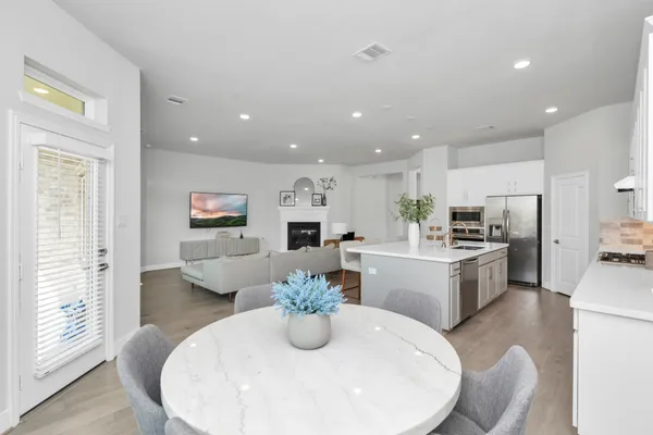 a kitchen with sink refrigerator dining table and chairs