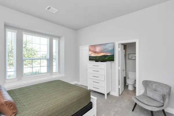 a bedroom with furniture and a flat screen tv
