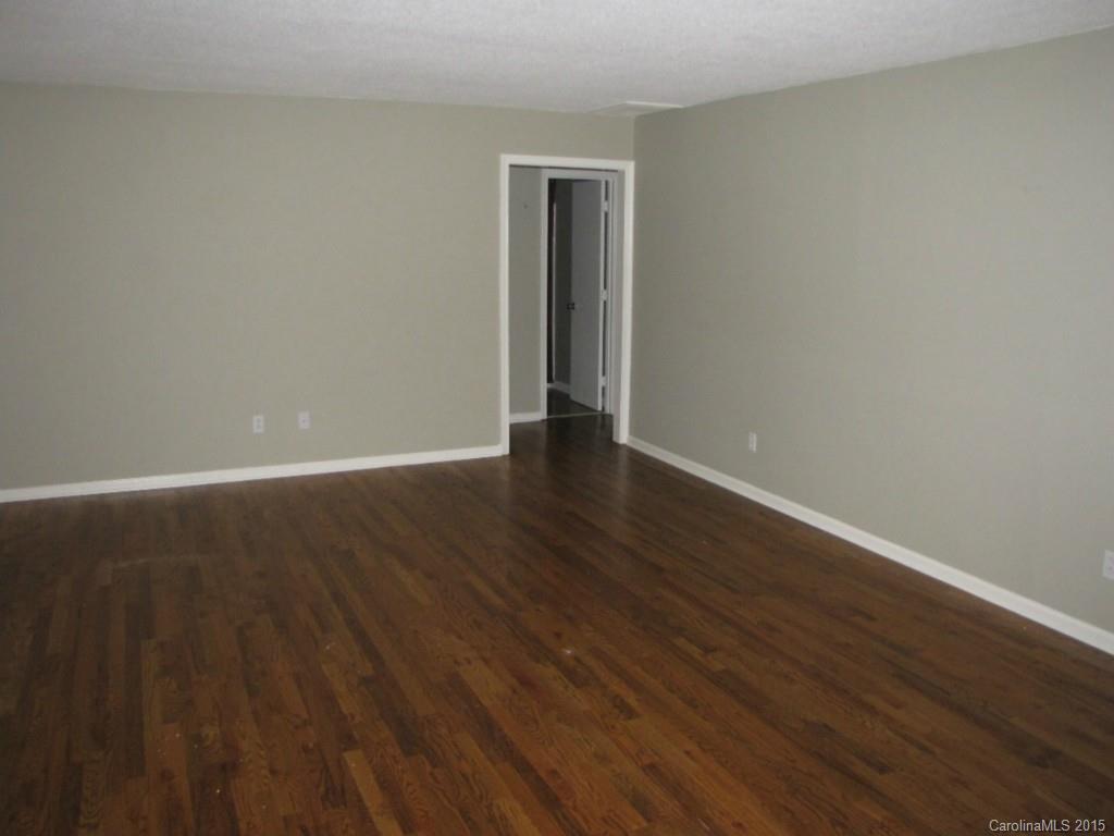 6133 Williams Road Charlotte, NC 28215 - Photo 4 of 14 a view of an empty room with wooden floor and a window