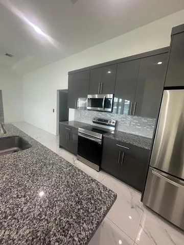 a kitchen with a stove a refrigerator and a sink