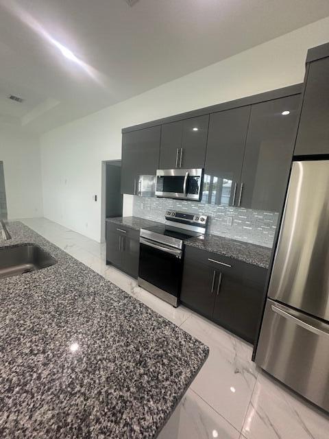 1726 Southwest California Boulevard Port St. Lucie, FL 34953 - Photo 12 of 41 a kitchen with a stove a refrigerator and a sink