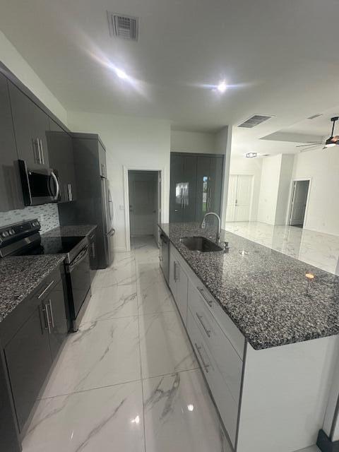 1726 Southwest California Boulevard Port St. Lucie, FL 34953 - Photo 14 of 41 a large kitchen with kitchen island granite countertop a sink and dishwasher a stove with wooden floor